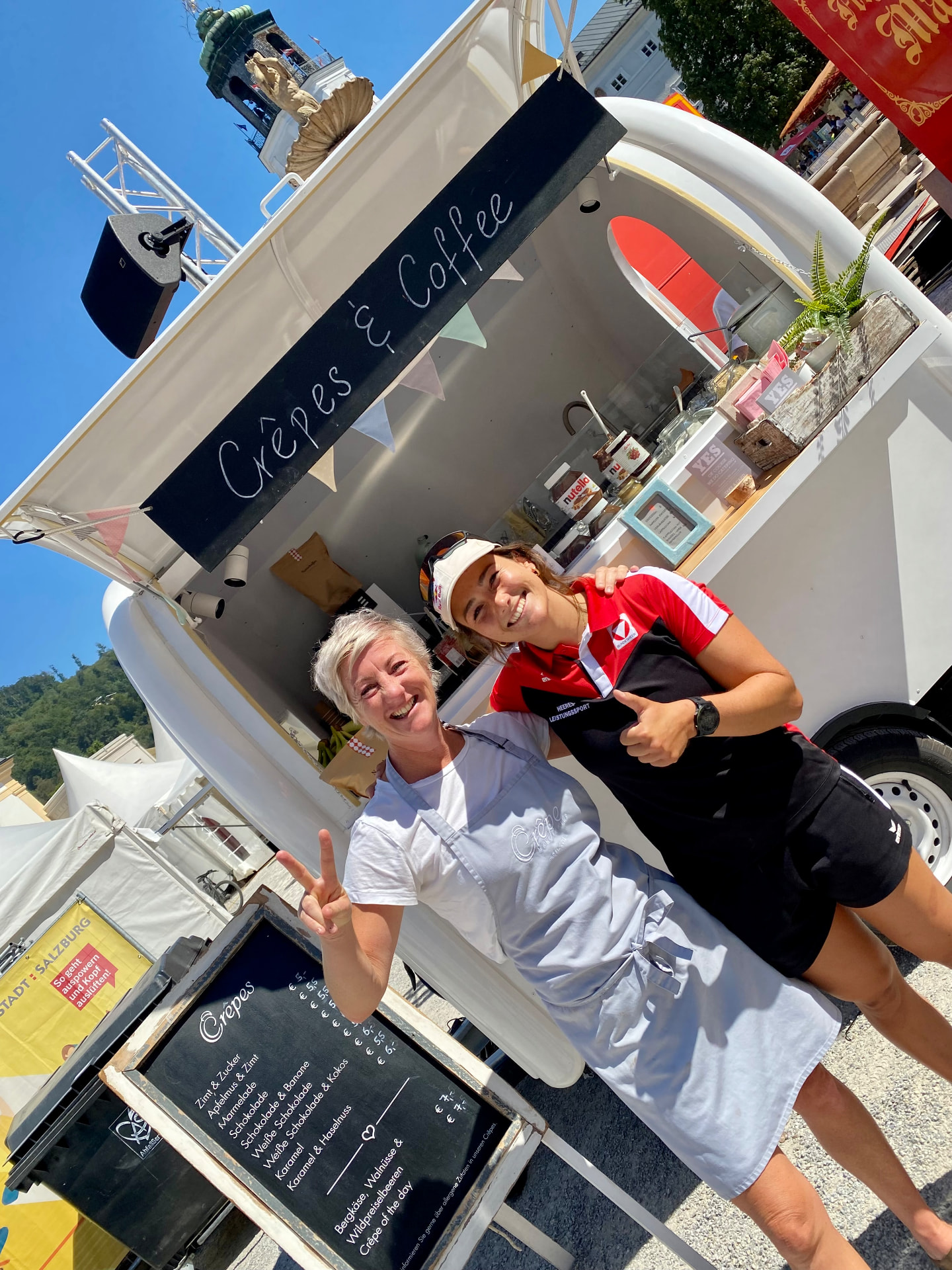 Crêpe-Trailer beim Tag des Sports am Residenzplatz in Salzburg mit Betreiberin und Sportlerin