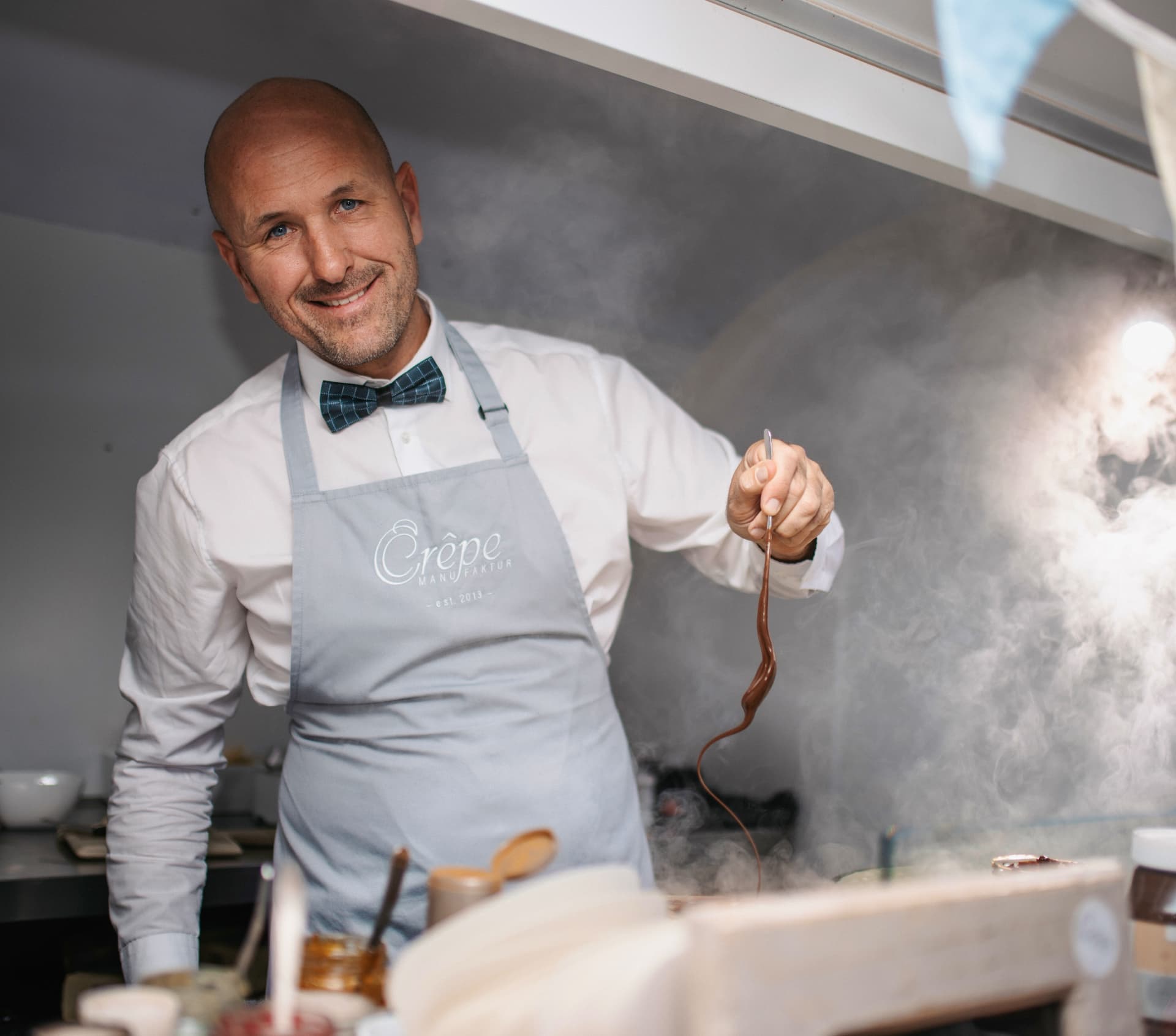 Betreiber der Crêpe Manufaktur bei der Zubereitung eines Crêpes im Trailer